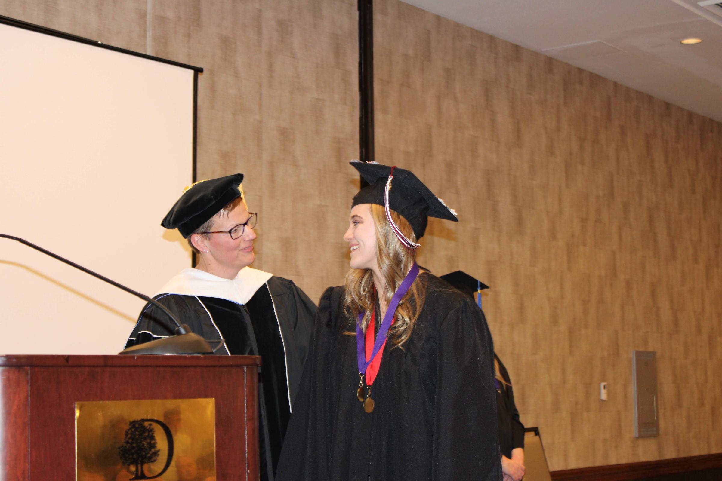 Dr. Basler congratulates newest nursing grad.